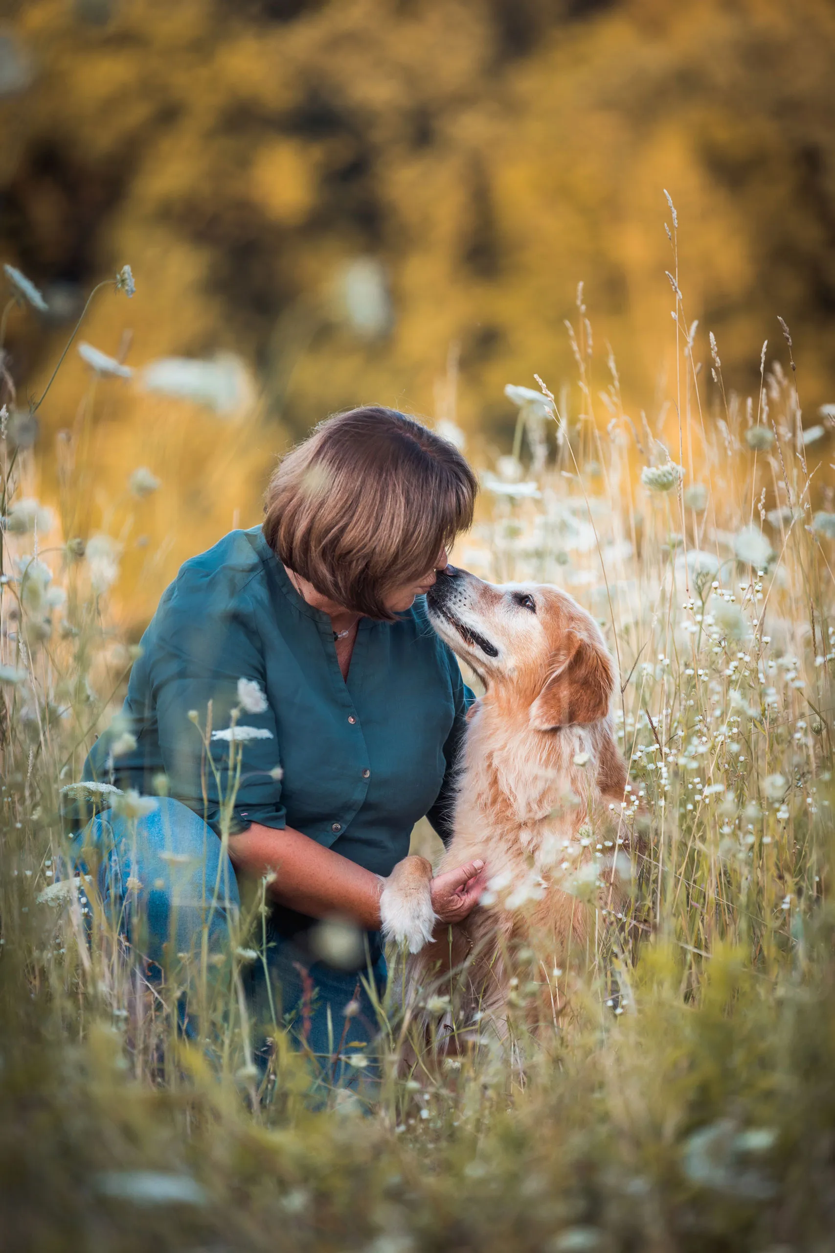 Silvia Hein beugt sich liebevoll zu ihrem Golden Retriever hinunter